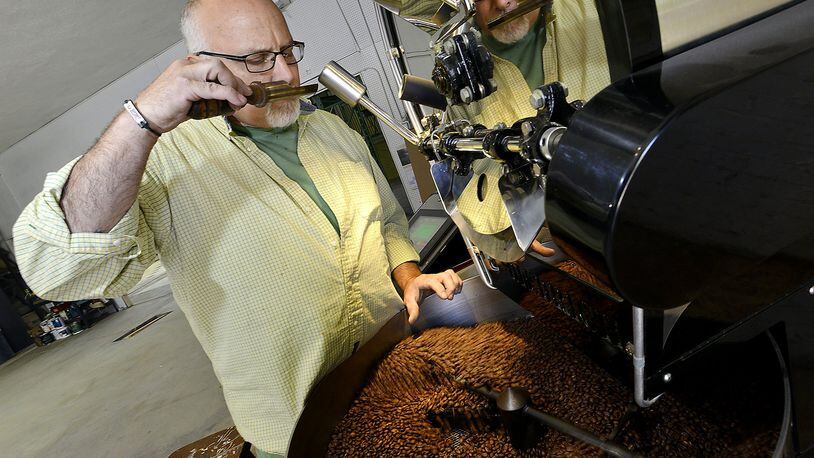 Paul Kurtz, owner of Hemisphere Roasters in Mechanicsburg, smells the freshly roasted coffee beans as they cool after coming out of the roaster in his warehouse location in 2014. Bill Lackey/Staff