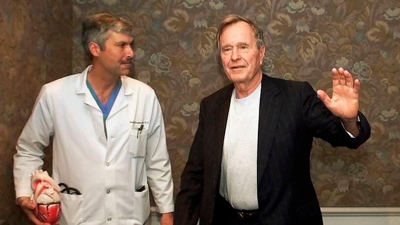Former President George H.W. Bush waves with his cardiologist, Mark Hausknecht, after a news conference in Houston in 2000. Hausknecht was shot and killed by a fellow bicyclist Friday, July 20, 2018, while riding through a Houston medical complex.