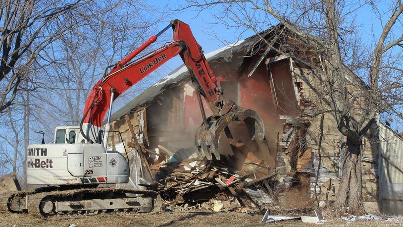Tony Smith from Smith Wrecking demolishes this home on Broadgauge Road in Clark County on Wednesday morning. Clark County received about $150,000 in matching grant money to demolish vacant and abandoned homes in the county. Jeff Guerini/Staff