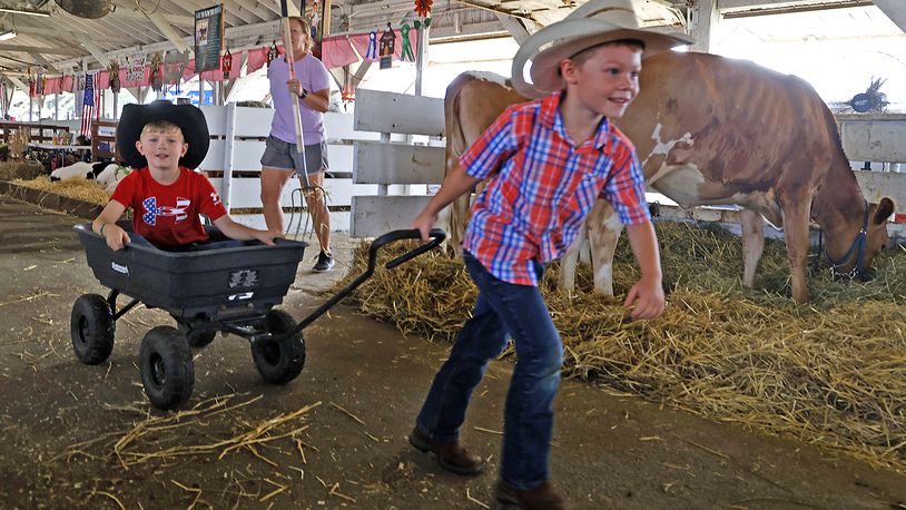 Jackson Cooke, left, and his cousin, Bodie, take turns pulling earch other around one of the cattle barns Monday, July 24, 2023 at the Clark County Fair. BILL LACKEY/STAFF