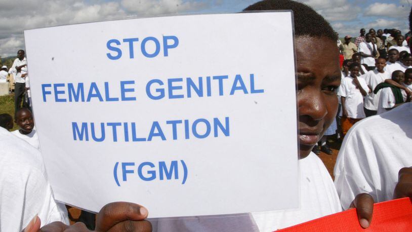 A Masai girl holds a protest sign during the anti-Female Genital Mutilation (FGM) run in Kilgoris, Kenya, April 21, 2007. (AP Photo/Sayyid Azim)