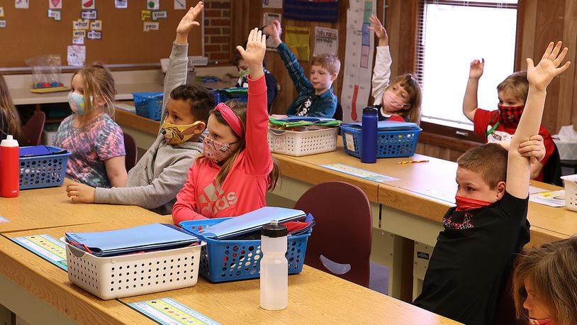 First grade students from Reid School raise their hands to answer a question at The Village. Students and teachers at Reid School had to be relocated to other buildings in the Clark Shawnee School District after Reid became unsafe. BILL LACKEY/STAFF