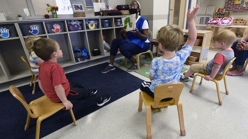 Valissa Williams, assistant teacher, Child Development Center, Wright-Patterson Air Force Base, reads a book to toddlers in August 2020. (U.S. Air Force photo/Ty Greenlees)