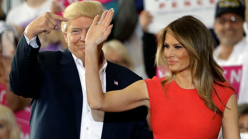 President Donald Trump points to his wife, first lady Melania Trump during a campaign rally Saturday, Feb. 18, 2017, at Orlando-Melbourne International Airport, in Melbourne, Fla. (AP Photo/Chris O'Meara)