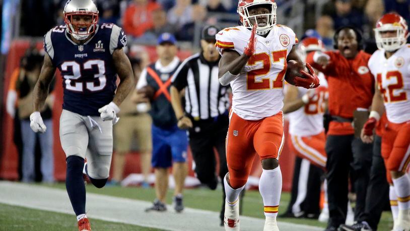 Kansas City Chiefs running back Kareem Hunt (27) runs from New England Patriots safety Patrick Chung (23) during the second half of an NFL football game, Friday, Sept. 8, 2017, in Foxborough, Mass. (AP Photo/Steven Senne)