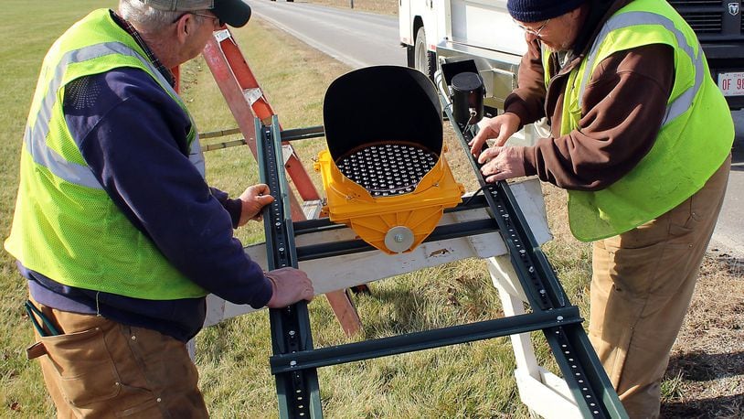 Clark County Engineer’s Department employees, (right) Keith Yeary and Tom Smith install a traffic sign to warn motorists to slow down in this 2016 photo. In 2018, Clark County employees will see insurance costs raise by about 1 percent. JEFF GUERINI/STAFF