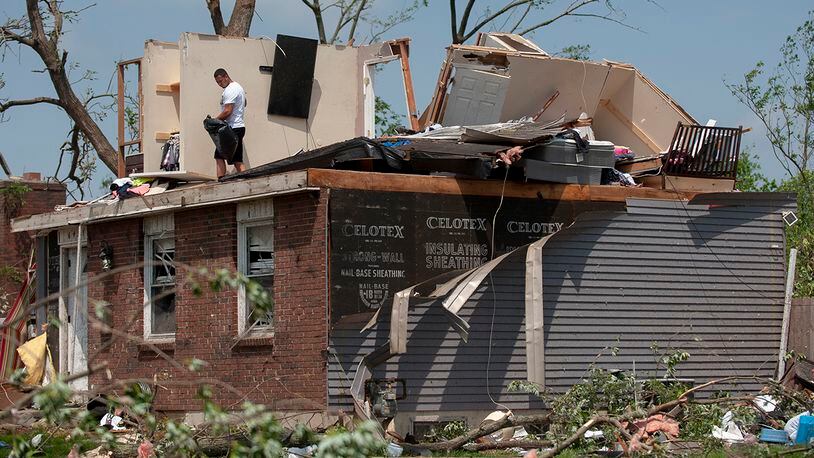 Residents in the West Brook neighborhood cut tree limbs and pick up scattered debris the morning after a suspected ef-4 tornado touched down early in the morning on May 28, 2019 in Trotwood, Ohio. One person was killed and multiple other injured. (Photo by Matthew Hatcher/Getty Images)
