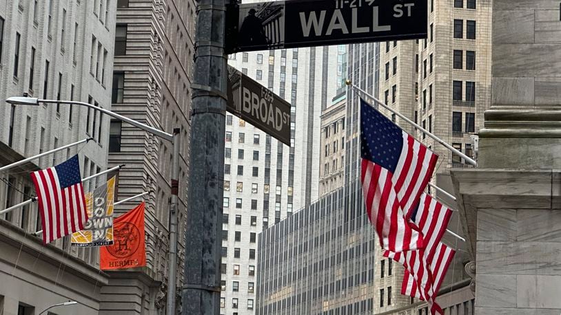 FILE - American flags hang from the front the New York Stock Exchange, right, on April 11, 2024 in New York. Global shares are trading higher on Friday, May 10, 2024, after a rally on Wall Street that pulled the S&P 500 back within 1% of its record. (AP Photo/Peter Morgan, File)
