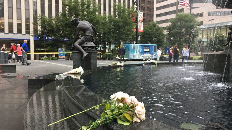 Ten bouquets of flowers decorated the rim of the fountain on Cincinnati's Fountain Square on Friday, Sept. 7, 2018, the day after a shooting in a nearby building. Three people were killed Thursday morning by Omar Santa-Perez, who then was killed by police responding to the active shooter calls. Two other people were seriously injured in the shooting. ERIC SCHWARTZBERG / STAFF