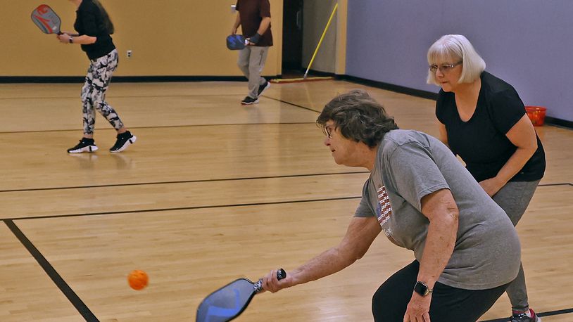 Helen Webb returns the ball as her partner, Ica Vega, stands by during their pickleball match at United Senior Services in Springfield on Wednesday, April 19, 2023. BILL LACKEY/STAFF