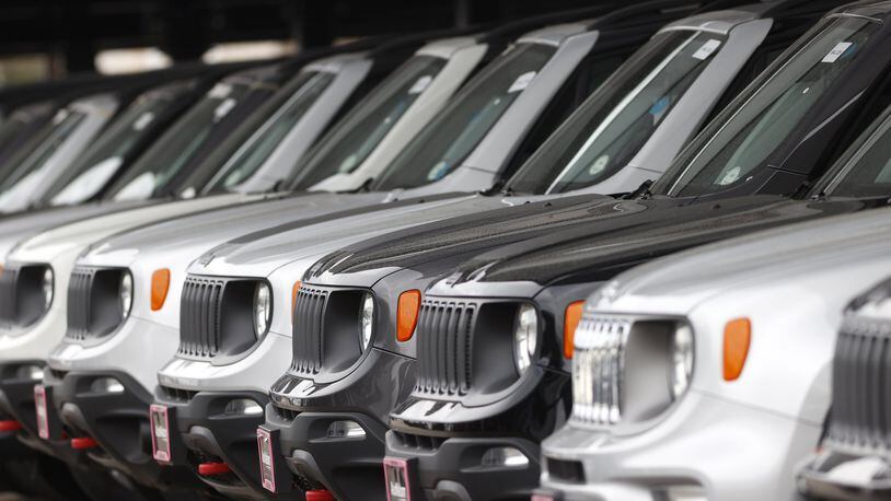 In this Sunday, April 26, 2020, photograph, a long row of unsold 2020 Renegades sits at a Chrysler/Jeep dealership in Englewood, Colo. Edmunds analysts had anticipated more than a million leased vehicles coming back to car dealerships this quarter. But due to countless shelter-in-place orders due to coronavirus concerns, many people will face the question of how to safely handle their vehicle’s lease return or whether they can return their vehicle at all. (AP Photo/David Zalubowski)