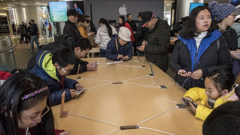 Visitors check out the iPhone 6s at an Apple store in Beijing in late 2015. China’s Foxconn plant in Zhengzhou, which makes about half of all iPhones, produces 500,000 a day, or roughly 350 a minute. (Gilles Sabrie/The New York Times)