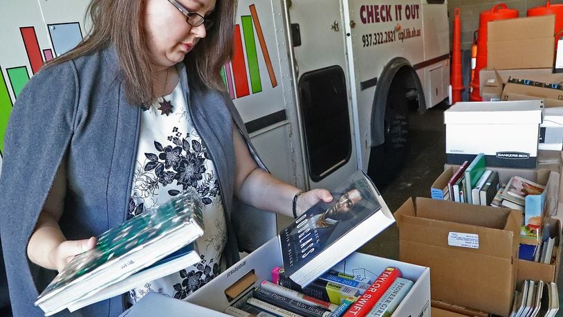 Allison Peck sorts through boxes of books Tuesday, Oct. 4, 2022 for the Friends of the Clark County Library's book sale. The annual event will have over 15,000 books, DVDs and other media items. BILL LACKEY/STAFF