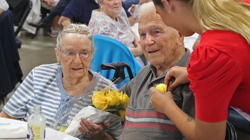 Rebekah Hardacre, the 2022 Clark County Fair Queen, pins a yellow rose on John Brown as he and his wife, Anna May, are crowned the King and Queen of the Golden Wedding Party Tuesday, July 26, 2022. The Browns have been married for 75 years. BILL LACKEY/STAFF
