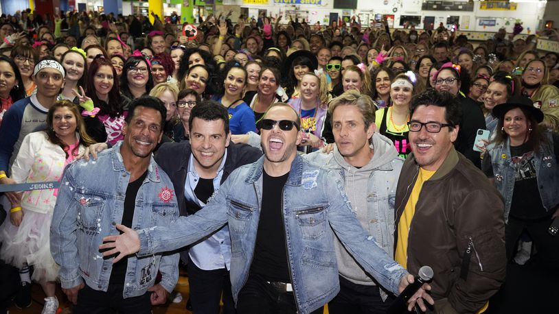 New Kids On The Block members, from left, Danny Wood, Jordan Knight, Donnie Wahlberg, Joey McIntyre and Jonathan Knight pose with fans at an 80's style roller rink party to celebrate their new single, at South Amboy Arena Rollermagic, on Thursday, March 3, 2022, in New Jersey. (Photo by Charles Sykes/Invision/AP)