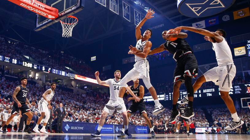 CINCINNATI, OH - DECEMBER 02: Gary Clark #11 of the Cincinnati Bearcats looks to keep the ball as Kaiser Gates #22 and Paul Scruggs #1 of the Xavier Musketeers defends at Cintas Center on December 2, 2017 in Cincinnati, Ohio. (Photo by Michael Hickey/Getty Images)