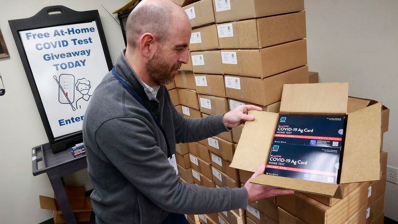 Nate Smith, from the Clark County Combined Health District, opens one of the hundreds of boxes filled with COVID-19 test kits Tuesday at the Health District office. The health department is giving away free test kits Wednesday from 8:30 a.m. to 4:30 p.m. Wednesday, Dec. 21, 2022, at their Home Road location. BILL LACKEY/STAFF