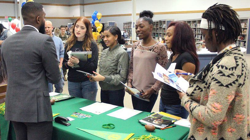 Springfield High School students listen to (left) Joshua Williams an admissions counselor at Kentucky State University on what his school has to offer for higher education. JEFF GUERINI/STAFF