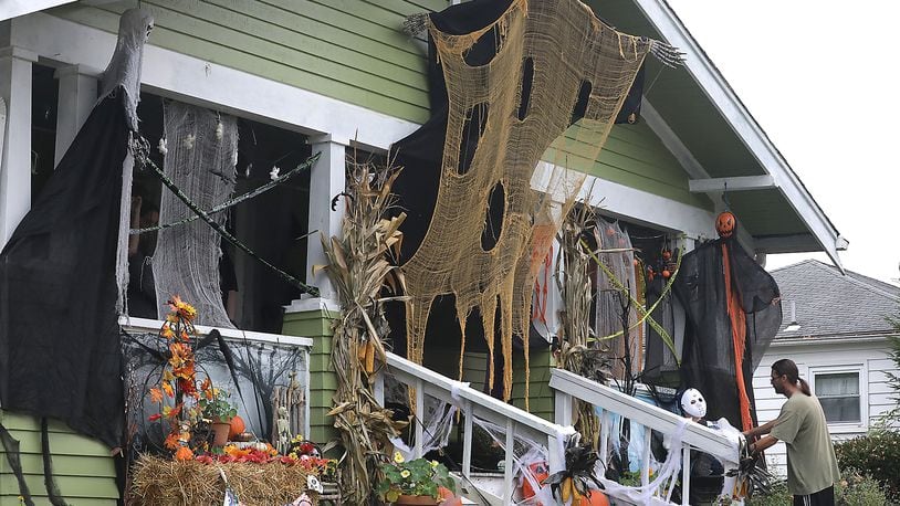 Mo Nagle puts the finishing touches on the Halloween decorations on his house along East Cecil Street in Springfield Monday. According to Nagle, his family decorates every year for Halloween. BILL LACKEY/STAFF