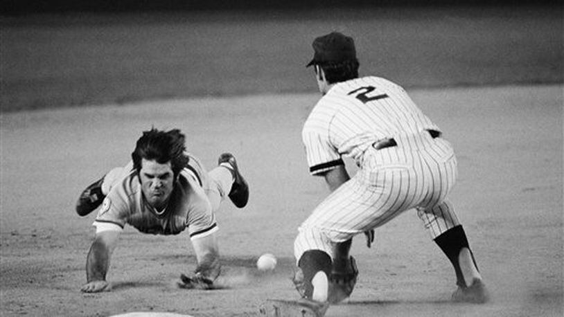 Pete Rose of the Cincinnati Reds slides head first, feet in the air, as he races the ball for third base with a seventh inning triple at Shea Stadium in New York, Friday, August 13, 1976. New York Mets third baseman Roy Staiger, (right) awaits the late throw from rightfielder Mike Vail. (AP Photo/Ray Stubblebine)