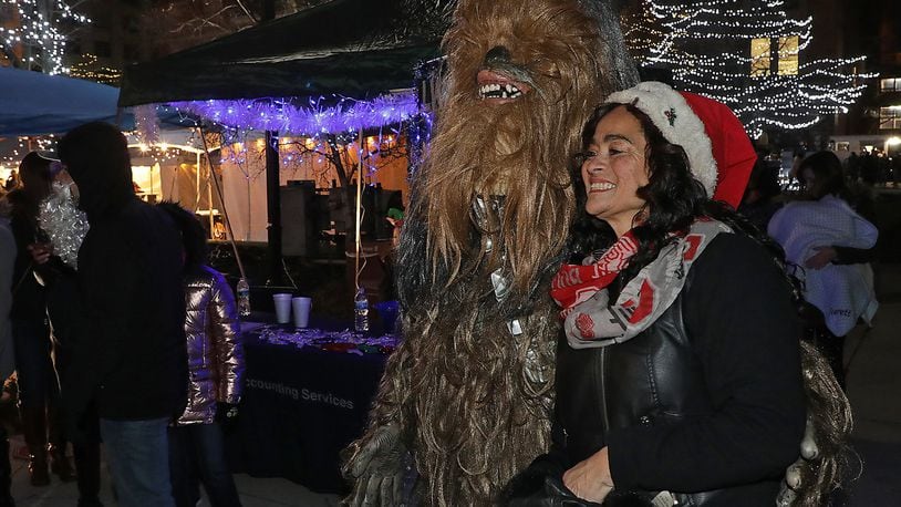 Alyce Comer gets her picture taken with Chewbacca from Star Wars at the LWS Tax and Accounting Kettle Wars booth at Holiday in the City Saturday. BILL LACKEY/STAFF