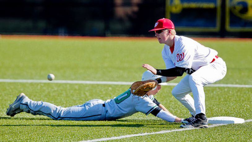 Mason's Marcus Otte slides safely into first base during a pick-off attempt to Lakota West's Troy Dombart during the Reds Futures High School Showcase at Prasco Park March 26, 2012, in Mason, Ohio.