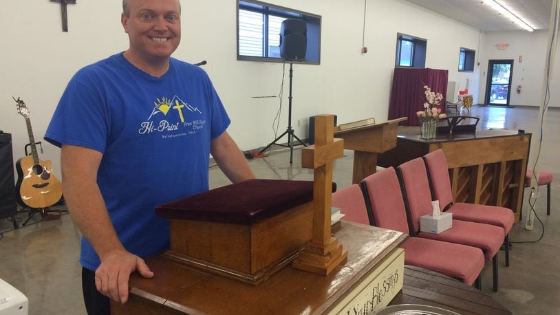 Pastor Scott Wisniewski stand at the pulpit donated to him after his church was destroyed by an explosion. KATHERINE COLLINS/STAFF