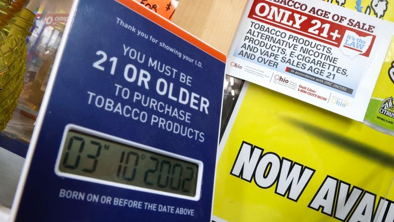 Signs on the counter of a Springfield convenience store remind customers that they must be 21 years old to purchase tobacco products. BILL LACKEY/STAFF