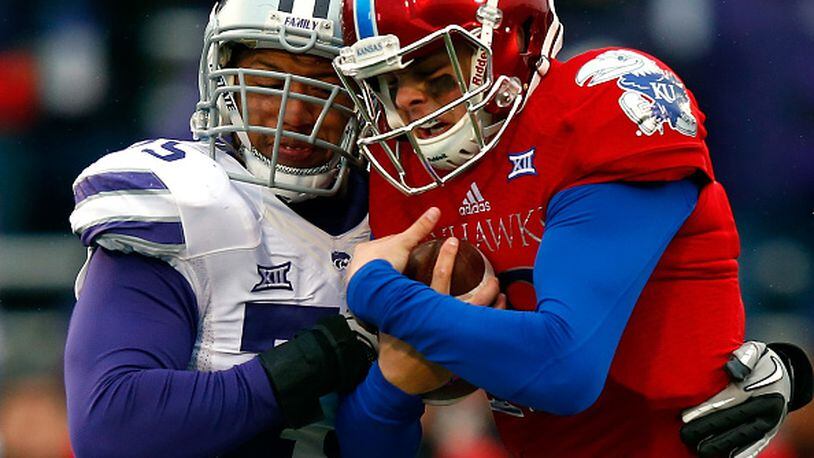 LAWRENCE, KS - NOVEMBER 28: Quarterback Ryan Willis #13 of the Kansas Jayhawks is sacked by defensive end Jordan Willis #75 of the Kansas State Wildcats during the game at Memorial Stadium on November 28, 2015 in Lawrence, Kansas. (Photo by Jamie Squire/Getty Images)