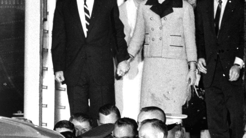 First Lady Jacqueline Kennedy, her dress stained with blood, stands with Attorney Gen.l Robert F. Kennedy, holding her hand, as they watch the casket of her slain husband, President John F. Kennedy, is placed in an ambulance at Andrews Air Force Base, Md., near Washington. The body of the president was flown from Dallas, Texas, where he was fatally shot earlier in the day. At right are Evelyn Lincoln and Kenneth O'Donnell of the White House staff. (AP Photo)