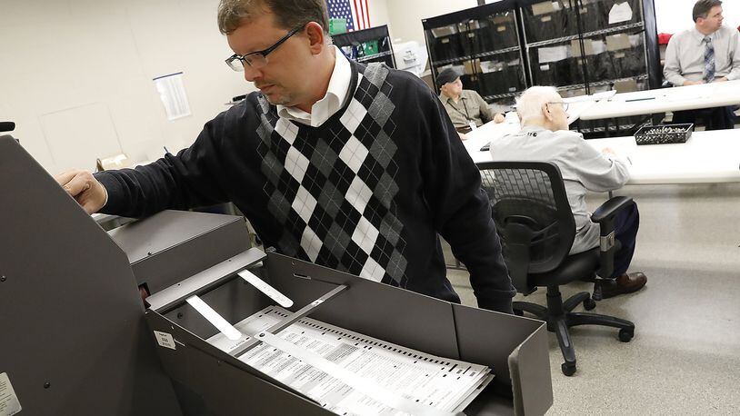 Jason Baker, director of the Clark County Board of Elections, runs the remaining ballots through a machine to count the votes for Springfield’s ballot issue last month. The Board of Elections and over departments have trimmed about three percent from its budget next year as the county will lose about $1 million in sales tax revenue next year and 3 million in 2018. Bill Lackey/Staff
