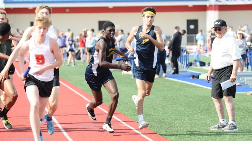 Springfield’s Vincent Fisher (left) receives the baton from Drew Heims during the boys 3,200-meter relay at the Division I district meet Wednesday at Piqua High School. Greg Billing / Contributed