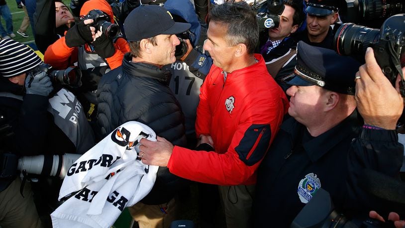 ANN ARBOR, MI - NOVEMBER 28:  Head coach Urban Meyer of the Ohio State Buckeyes shakes hands with head coach Jim Harbaugh of the Michigan Wolverines after a 42-13 Ohio State win at Michigan Stadium on November 28, 2015 in Ann Arbor, Michigan.  (Photo by Gregory Shamus/Getty Images)