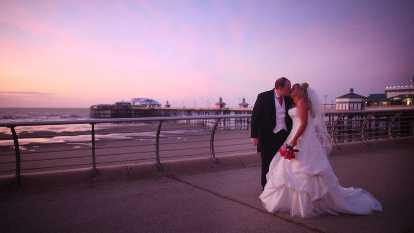 Newlyweds walk along a promenade after getting married on January 12, 2012. (Photo by Christopher Furlong/Getty Images)
