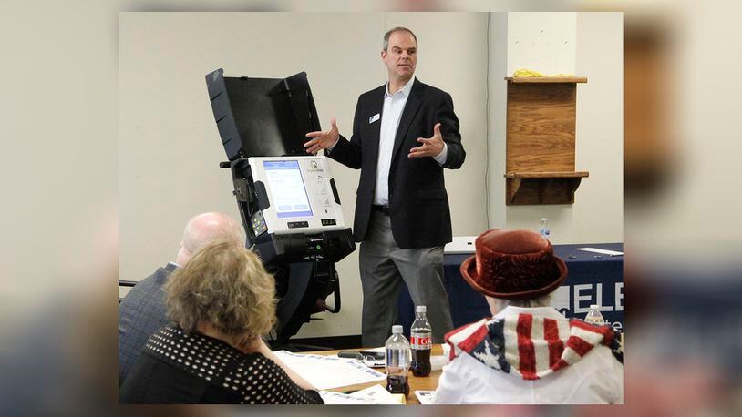 Craig Seibert, regional sales manager, from Election Systems & Software demonstrates a voting machine to the Greene County Board of Elections in Xenia. Dominion Voting Systems machines were demonstrated in a later session.    TY GREENLEES / STAFF