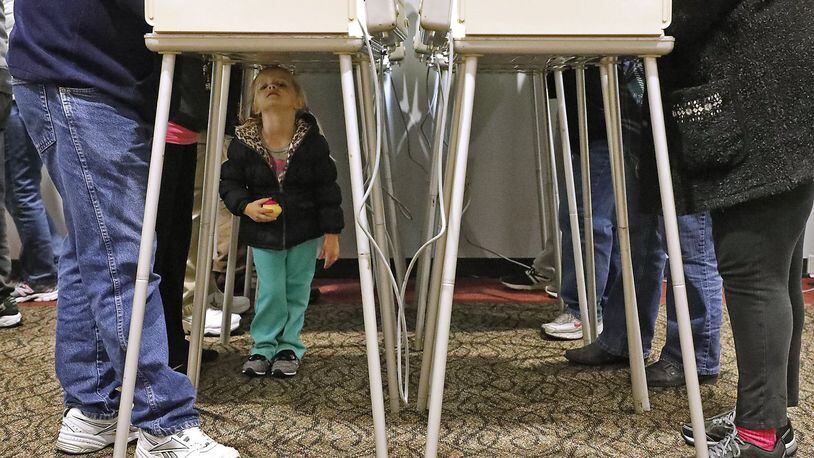 Kenzie Eisen, 4, plays under the voting booths as her mother casts her vote Tuesday at a Clark County election poll. Bill Lackey/Staff