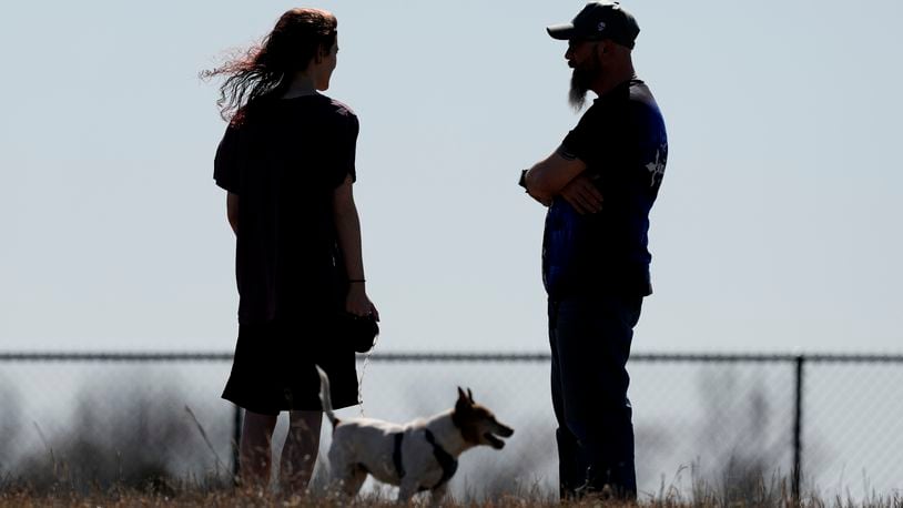 Dusty Farr talks with his transgender daughter at a park near Smithville, Mo., Sunday, Feb. 25, 2024. Farr is suing the Platt County School District after his daughter was suspended for using the girl's bathroom at the Missouri high school she attended. (AP Photo/Charlie Riedel)