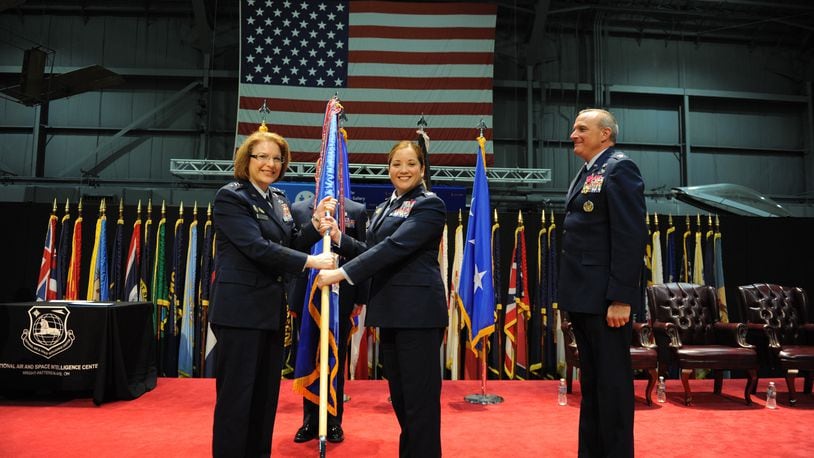 Col. Ariel G.  Batungbacal (center) takes command of the National Air and Space Intelligence Center after receiving the guidon from Lt. Gen. Mary F. O’Brien, Deputy Chief of Staff for Intelligence, Surveillance, Reconnaissance and Cyber Effects Operations (left) in June 2022. U.S. Air Force photo / Senior Airman Kristof J. Rixmann