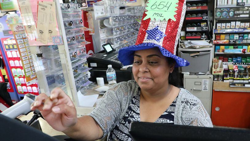 Hiral Patel was wearing a hat announcing the amount of the Mega Millions lottery Tuesday at the Plum Food Mart. The next Mega Millions lottery drawing is Friday night and the jackpot is around $970 million. BILL LACKEY/STAFF