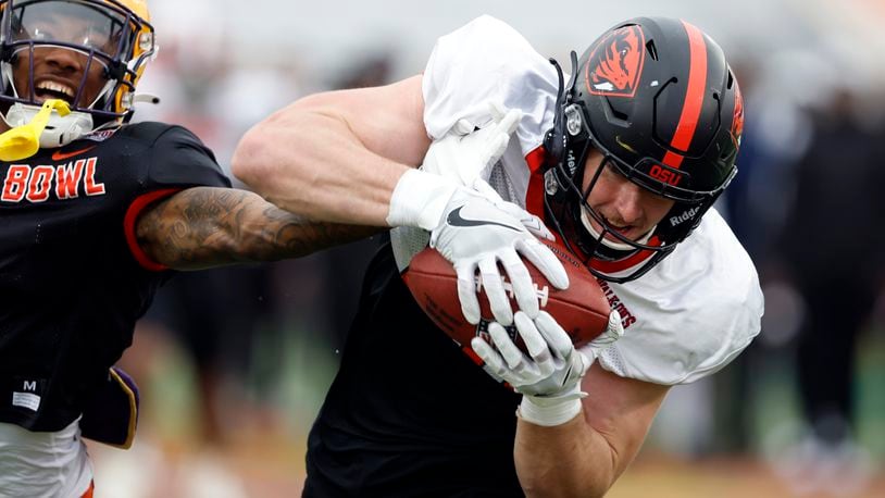 American tight end Luke Musgrave of Oregon State catches a pass over American defensive back Jay Ward of LSU during practice for the Senior Bowl NCAA college football game, Thursday, Feb. 2, 2023, in Mobile, Ala.. (AP Photo/Butch Dill)