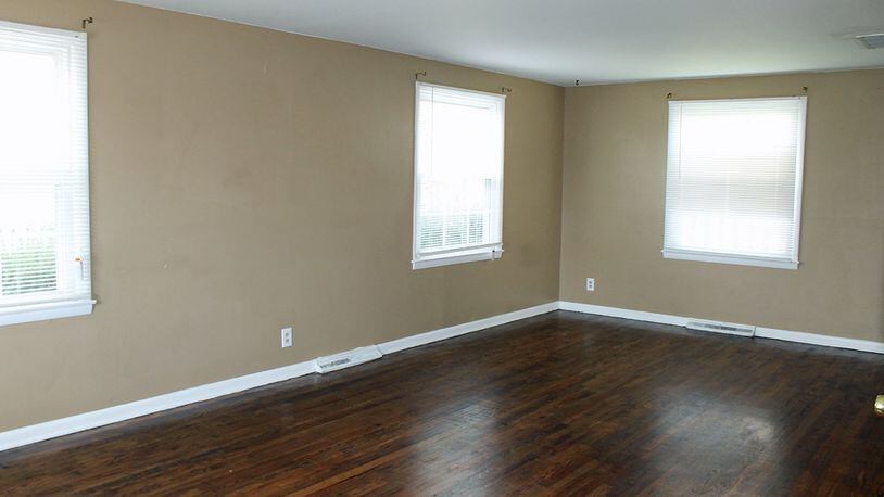 The living room features hardwood floors and several windows that allow for plenty of natural light.