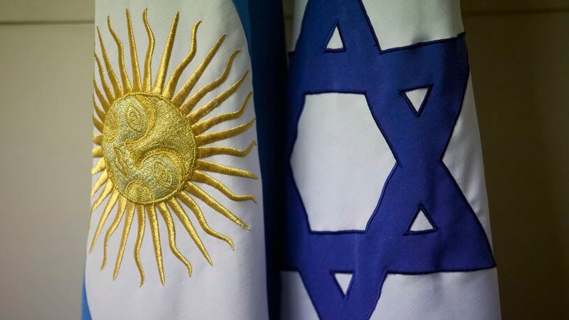 FILE - An Argentine and Israeli flag stand side by side at the office of Guillermo Borger, president of the Jewish community center AMIA, during an interview with The Associated Press in Buenos Aires, Argentina, on Feb. 8, 2013. Argentina’s highest criminal court on Thursday, April 12, 2024, reported a new development in the elusive quest for justice in the country’s deadliest attack in history – the 1994 bombing of a Jewish community center headquarters – concluding Iran had planned the attack and Lebanon’s Hezbollah militant group had executed the plans. (AP Photo/Victor R. Caivano)