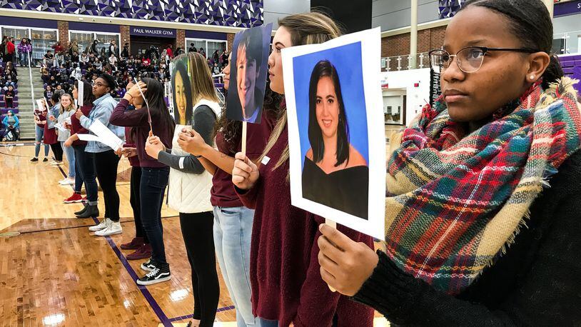 Middletown High School student Jasmynn Thomas, right, holds a picture of Parkland shooting victim Carmen Schentrup as students at Middletown High School participated in events Wednesday, March 14 as part of National Walk Out efforts to commemorate the deaths of 17 students who died from gunfire at a Parkland, Fla. high school. Students filled the Wade E. Miller Arena and 17 students read biographies of those killed in the Parkland school shooting. NICK GRAHAM/STAFF