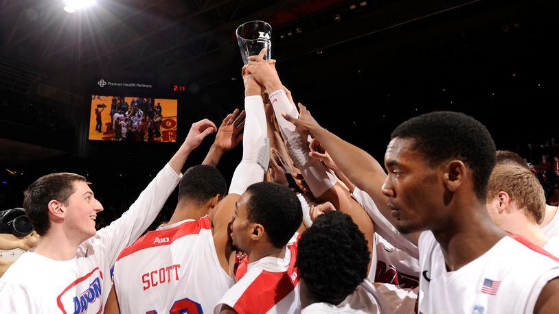 The Dayton Flyers hold up the Blackburn-Mcafferty trophy after defeating Xavier 70-59.