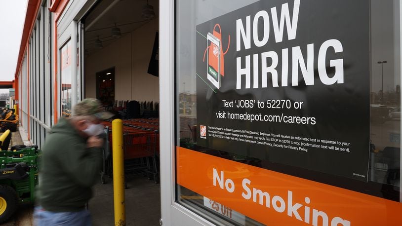 A customer walks past a "Now Hiring" sign at the entrance to Home Depot in Springfield earlier this year. BILL LACKEY/STAFF