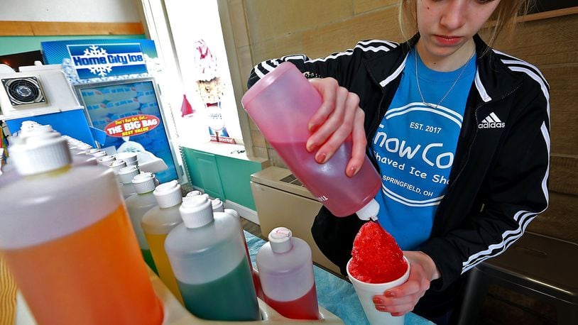 Reagan Patton makes a shaved ice treat at Snow Cove Shaved Ice Shop. BILL LACKEY/STAFF