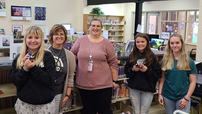 Tecumseh Middle School offers a "Career Cafe" for student to look at different Springfield-Clark Career Technology programs each month during study hall. In this photo is Kathy Oaster (middle) with Melinda Scaggs (second from left) and students with the Lego cars they made for the automotive unit. Contributed