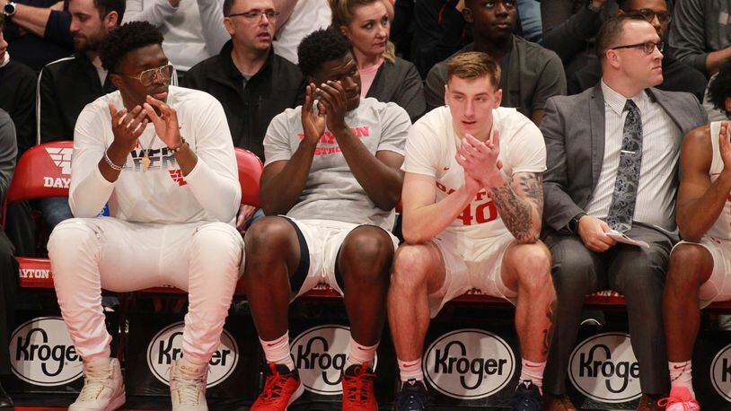 Dayton players (left to right) Jordy Tshimanga, Moulaye Sissoko and Chase Johnson watch from the bench during a game against Charleston Southern on Saturday, Nov. 16, 2019, at UD Arena.