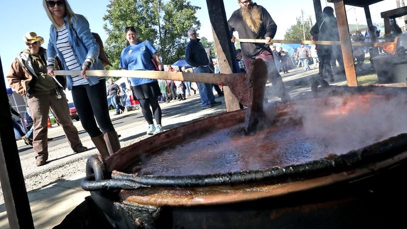 Shannon Webb takes a turn at stirring one of the giant kettles of apple butter cooking over an open fire at the 2019 Enon Apple Butter Festival Saturday. Organizers have canceled this year’s festival due to the coronavirus pandemic. BILL LACKEY/STAFF
