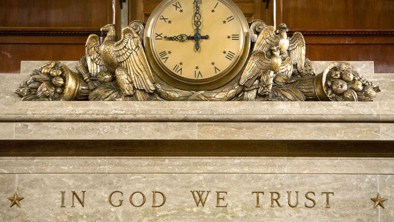 A clock and the motto 'In God We Trust' over the Speaker's rostrum in the U.S. House of Representatives. In Kentucky, school officials may soon be posting the national motto in a prominent place in their buildings